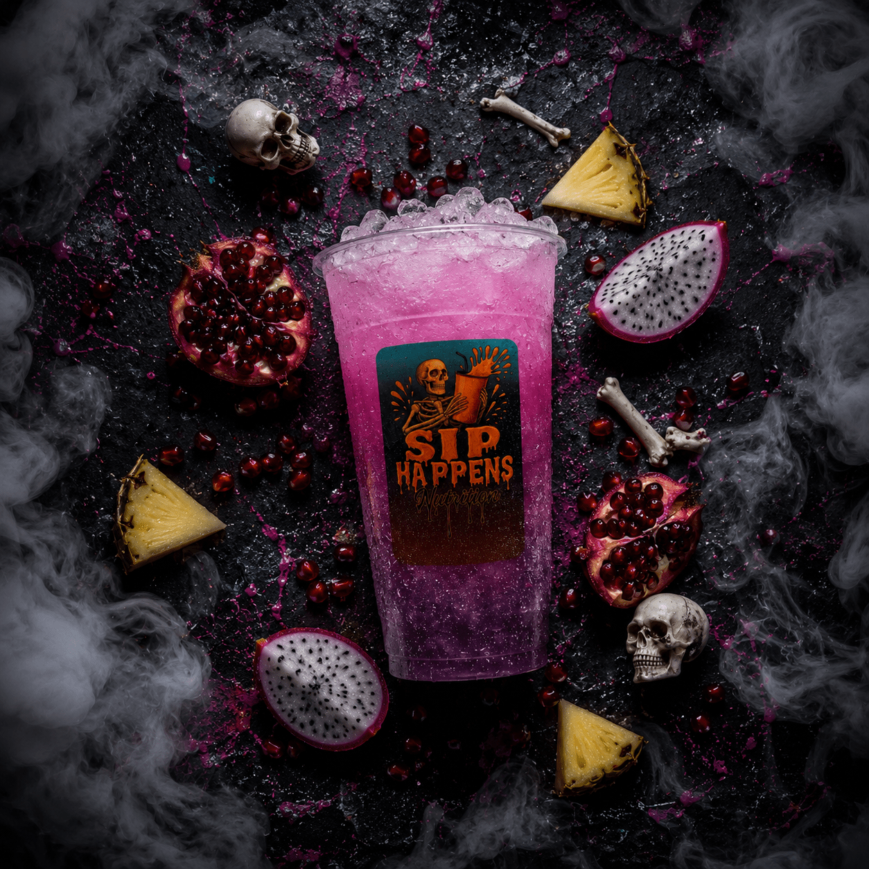 Sip Happens Nutrition branded cup filled with a purple iced drink, surrounded by pomegranate, dragon fruit, pineapple, and Halloween skull props with dramatic smoke effects