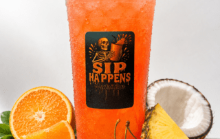 Sip Happens Nutrition iced drink in a large cup surrounded by orange slices, cherries, pineapple, and coconut