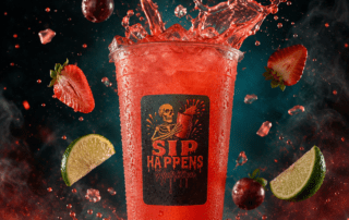 Sip Happens Nutrition red iced drink splashing with strawberries, cherries, and lime slices surrounding the cup