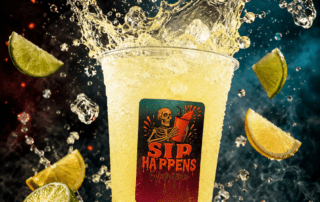 Sip Happens Nutrition iced drink splashing with lime, lemon, and coconut pieces scattered around the cup