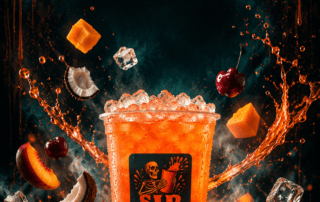 Sip Happens Nutrition iced orange drink surrounded by splashing liquid, cherries, peach slices, mango, and coconut pieces